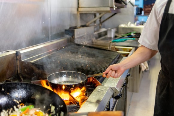 Flames under a frying pan in a kitchen