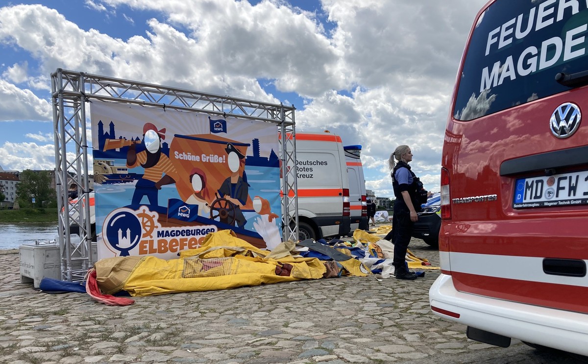 05.05.2024, Sachsen-Anhalt, Magdeburg: Einsatzfahrzeuge stehen am Elbufer neben einer zusammengefallenen H�pfburg. Mehrere Kinder sind am Sonntag in Magdeburg verletzt worden, als bei einer Veranstalt ...
