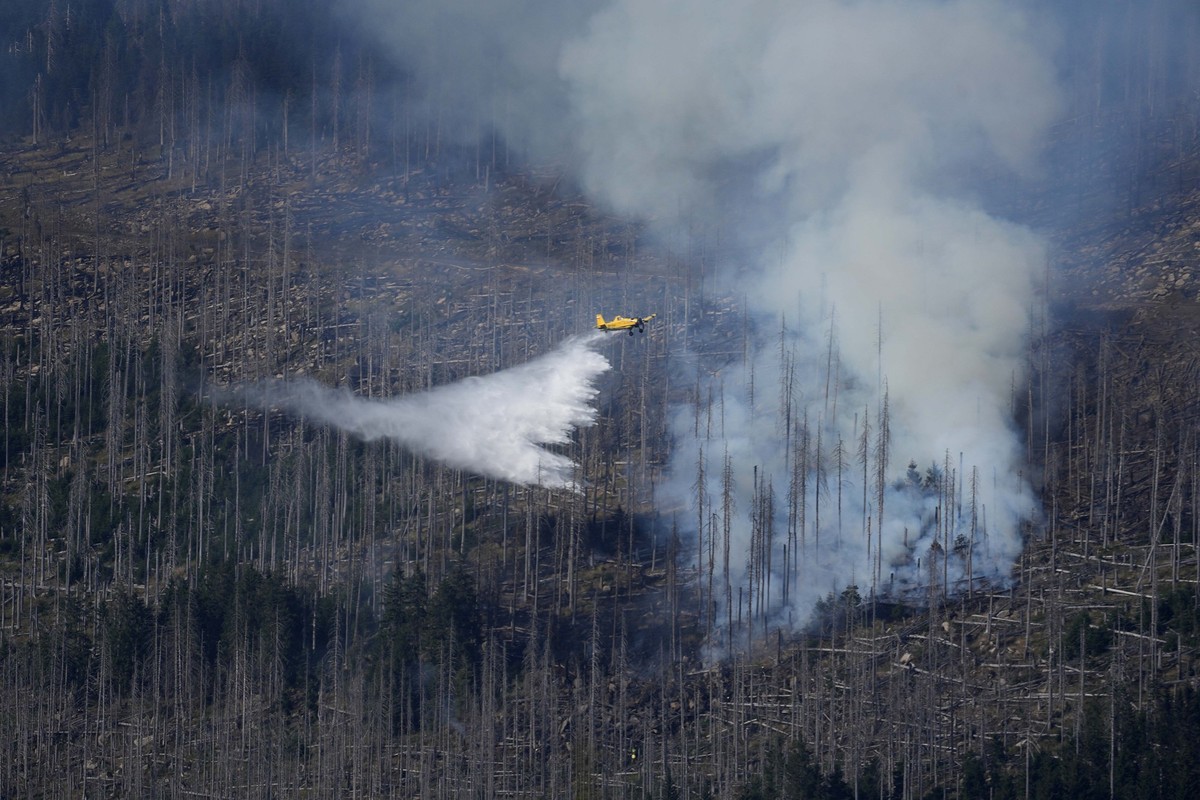 A plane drops water over a fire at the Harz Mountains below the Brocken peak about 30 km (18.6 miles) west of Wernigerode in northern Germany near Schierke, Germany, Saturday, Sept. 7, 2024. (AP Photo ...