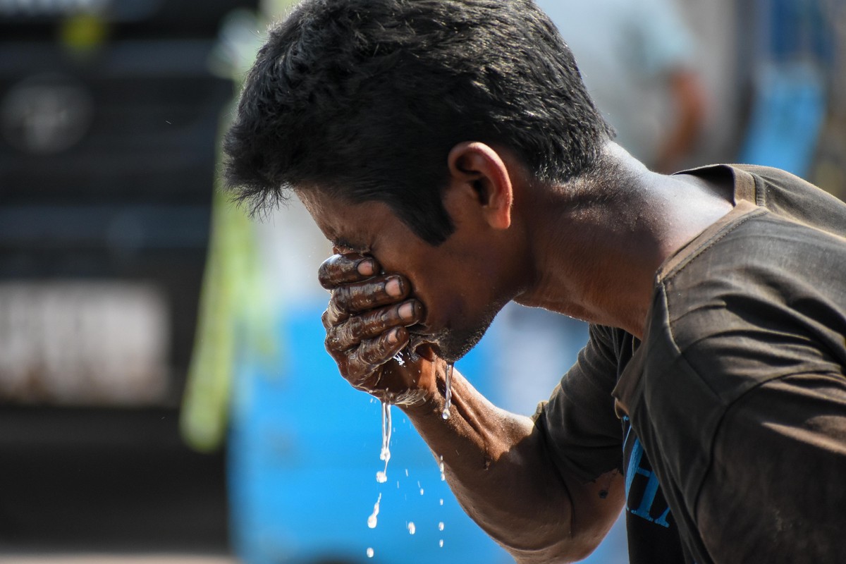 A man is seen splashing water on his face to escape from severe heat wav in Kolkata , India , on 29 April 2022 . Indian meteorological department ( IMD ) has issued heat wave alert in as many as 15 st ...