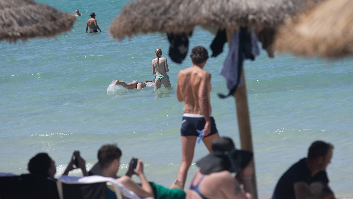 30.05.2025, Spanien, Palma: Menschen schwimmen und sonnen sich am Strand von Arenal auf Mallorca. Von Ende Mai bis zum kommenden Montag herrscht in Spanien eine frühlingshafte Hitzewelle mit Temperatu ...