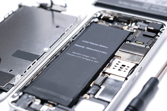 Professional occupation services concept - repairing modern smartphone motherboard in a professional laboratory in close-up
