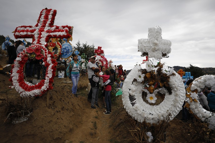 Mourners visit other graves following the burial of community activist Homero Gomez Gonzalez, in Ocampo, Michoacan state, Mexico, Friday, Jan. 31, 2020. Hundreds of farmers and agricultural workers at ...