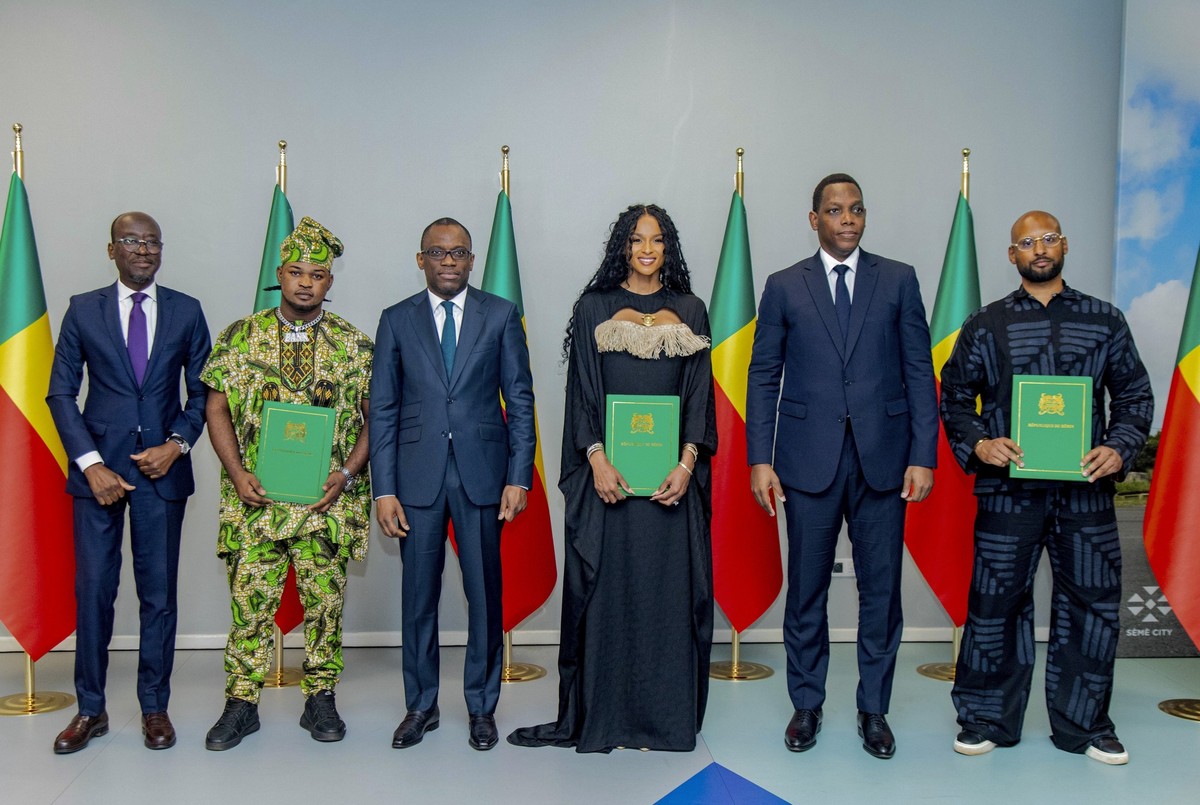 Singer Ciara, center, poses for a photo with government officials and other beneficiaries of the diaspora program with their citizenship documents during a ceremony in Cotonou, Benin, Saturday July 26 ...