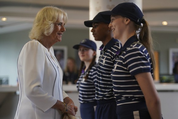 Queen Camilla, left, meets ballboy and ballgirls Larissa, Sean Michael and Cassie as she arrives for her visit on day ten of the 2023 Wimbledon Championships at the All England Lawn Tennis and Croquet ...
