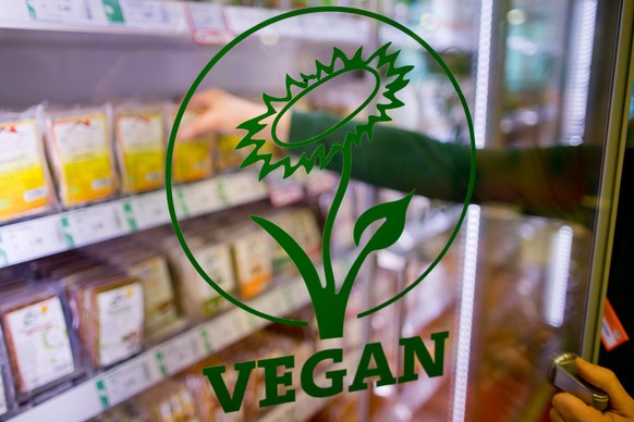 ARCHIV - 04.02.2016, Nordrhein-Westfalen, N�rnberg: �Vegan� ist auf der Glast�r eines K�hlregals mit veganen Produkten in einem Biosupermarkt zu lesen. Jugendmediziner raten vor einer veganen Ern�hrun ...