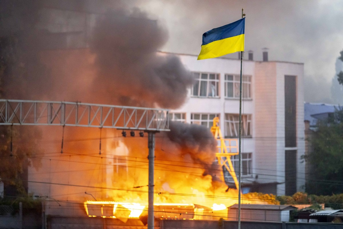 Ukraine flag seen in front of thick smoke which is rising from fire over Kyiv after Russian missile attacks on Ukraine. Kyiv City *** Ukraine flag seen in front of thick smoke which is rising from fir ...