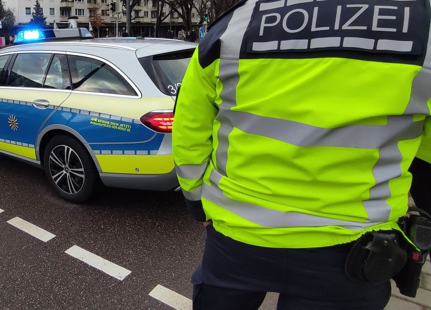 10.03.2023, Karlsruhe: Polizeifahrzeuge stehen auf einer Straße In Karlsruhe. Die Polizei wegen einer Geiselnahme in einem Großeinsatz. Das Tatgeschehen laufe noch, sagte ein Sprecher am frühen Freita ...