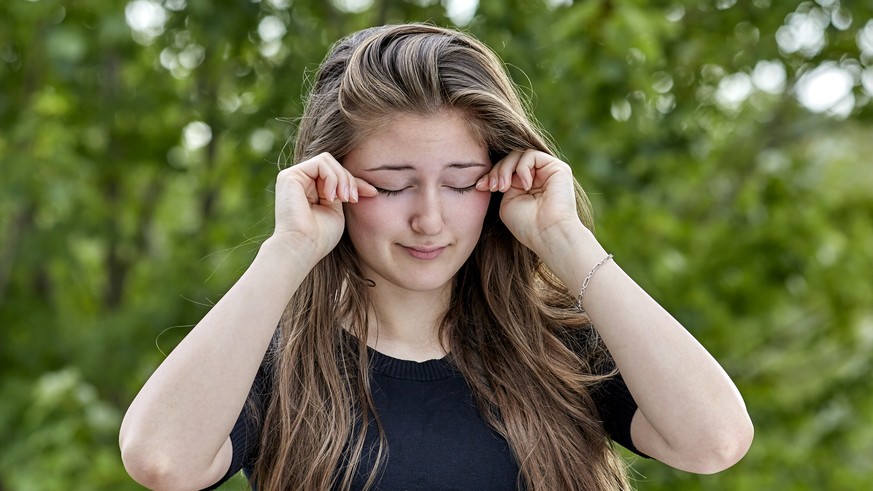 Sleepy young woman rubbing her eyes