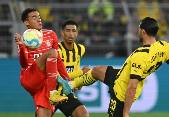 ARCHIV - 08.10.2022, Nordrhein-Westfalen, Dortmund: Fu�ball: Bundesliga, Borussia Dortmund - FC Bayern M�nchen, 9. Spieltag, Signal Iduna Park. M�nchens Jamal Musiala (l) und Dortmunds Emre Can (r) k� ...