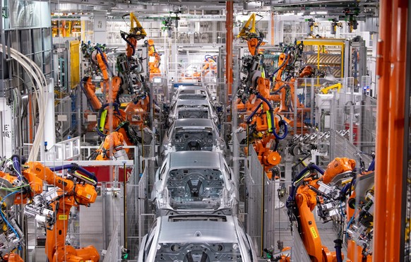 ARCHIV - 22.10.2021, Bayern, M�nchen: Roboter von ABB arbeiten an der Karosserie von verschiedenen BMW-Modellen im BMW-Stammwerk. (zu dpa: �BMW will mehr Elektroautos verkaufen - rekordhohe Investitio ...