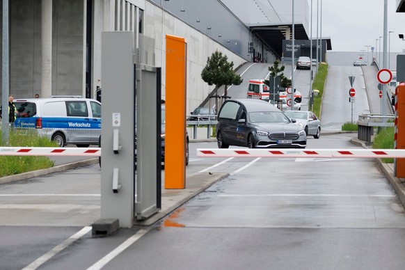 11.05.2023, Baden-Württemberg, Sindelfingen: Zwei Polizisten bewegen sich über das Werksgelände bei Tor 5. Bei Schüssen auf einem Werksgelände von Mercedes-Benz in Sindelfingen gab es Tote. Foto: Juli ...