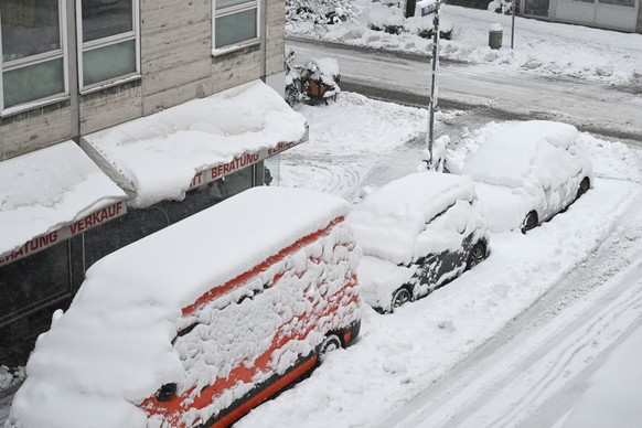 02.12.2023, Bayern, München: Hohe Schneemassen liegen auf Autos und einer Straße in der Landeshauptstadt. Schnee und Eis haben im Süden Bayerns auf den Straßen und bei der Bahn für Chaos gesorgt. Foto ...