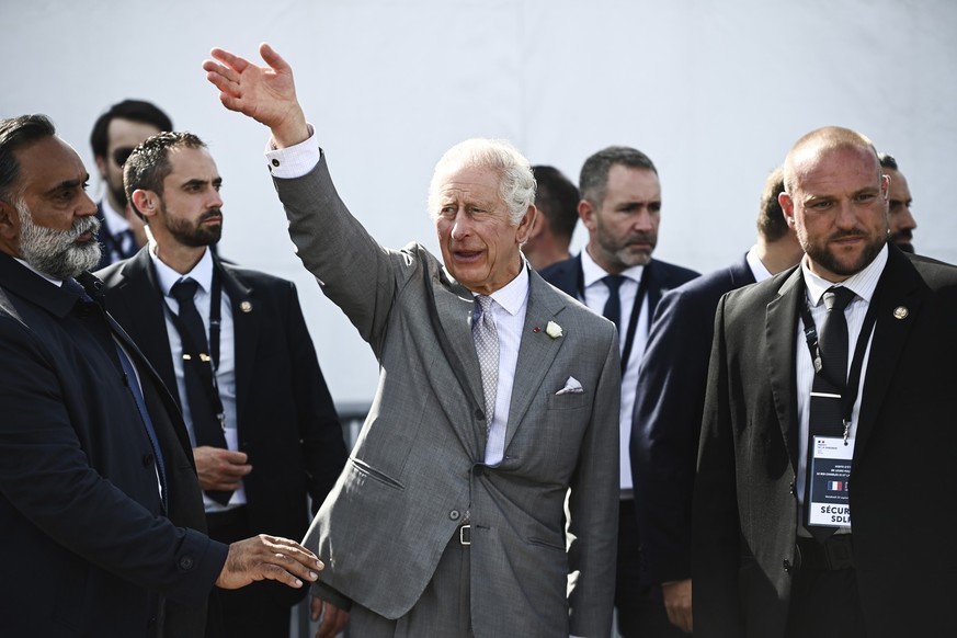 22.09.2023, Frankreich, Bordeaux: Der britische König Charles III. (M) winkt der Menge auf dem Place de la Bourse zu. Das britische Königspaar ist zum Abschluss seines dreitägigen Staatsbesuchs in Fra ...