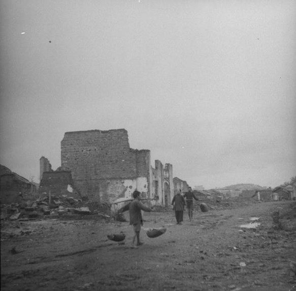 December 1945: People walking through the ruins of city which must be completely rebuilt because of air raids and looting by the Japanese during the occupation. (Photo by Jack Wilkes/The LIFE Picture  ...