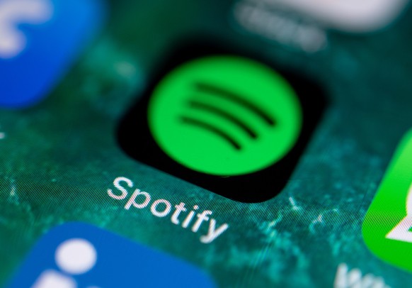 ARCHIV - 21.06.2019, Stuttgart: Die App des Musikdienstes Spotify wird auf dem Display eines iPhone angezeigt. (zu dpa &quot;Spotify: Zahl der K�nstler mit Millionen-Zahlungen nahm 2022 kaum zu&quot;) ...