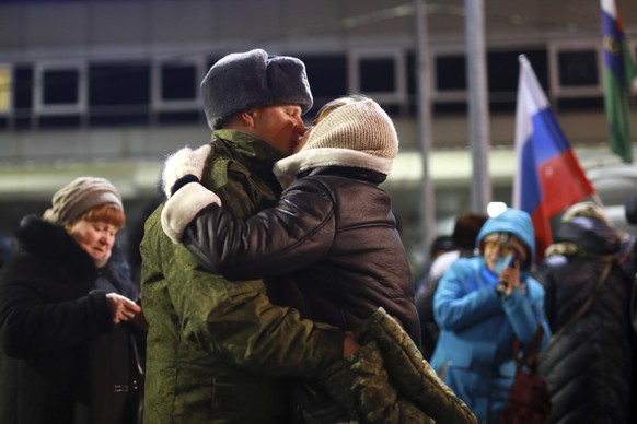 A soldier kisses a woman as other soldiers who were recently mobilized by Russia for the military operation in Ukraine gather before boarding a train at a railway station in Tyumen, Russia, Friday, De ...