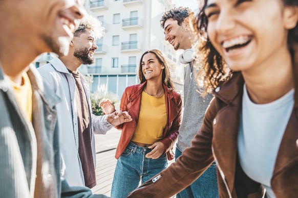 Multiraciale gelukkige vrienden die samen plezier hebben Wandelen door de straten van de stad - Een groep jonge mensen die op een zonnige dag in de stad rondhangen - Universiteitsstudenten praten en lachen luid op de universiteitscampus