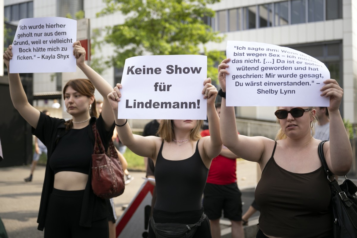 17.06.2023, Schweiz, Bern: Mitglieder der Jungsozialisten Schweiz (JUSO), von Campax und des feministischen Kollektivs Bern stehen mit Plakaten mit der Aufschrift �Keine Show f�r Lindemann� vor einem ...
