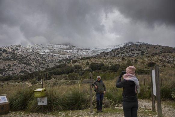 26/01/2023, España, Mallorca: Una mujer toma una foto del paisaje cubierto de nieve de la Serra de Tramuntana en Mallorca después de la última Nevada.  Después de un verano récord...