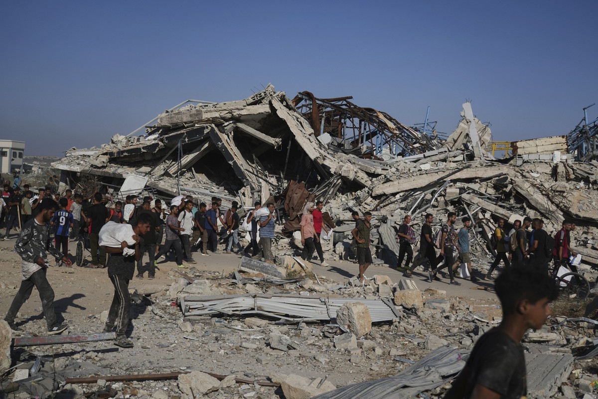 26.06.2025, Palästinensische Gebiete, Chan Junis: Palästinenser tragen humanitäre Hilfspakete in der Nähe des Verteilungszentrums der Gaza Humanitarian Foundation, das von der von den USA unterstützte ...