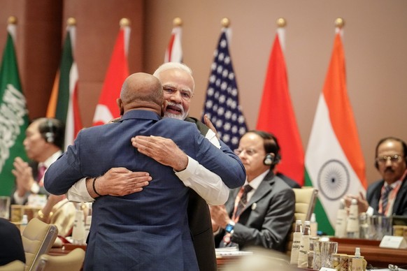 dpatopbilder - 09.09.2023, Indien, Neu Delhi: Narendra Modi (r), Premierminister von Indien, umarmt beim G20-Gipfel bei der ersten Arbeitssitzung mit dem Thema &quot;One Earth&quot; Azali Assoumani vo ...