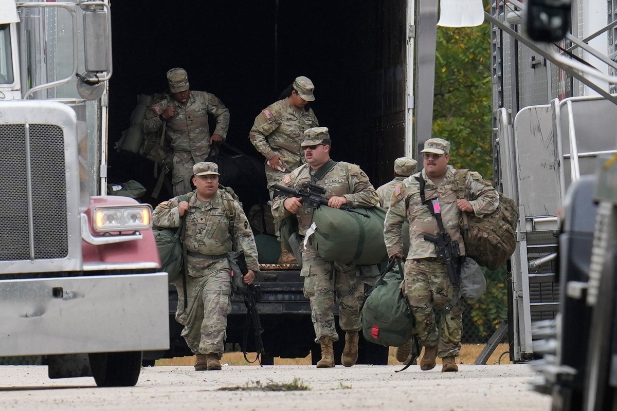 07.10.2025, USA, Elwood: Militärangehörige in Uniform mit dem Abzeichen der texanischen Nationalgarde kommen im U.S. Army Reserve Center an. Foto: Erin Hooley/AP/dpa +++ dpa-Bildfunk +++