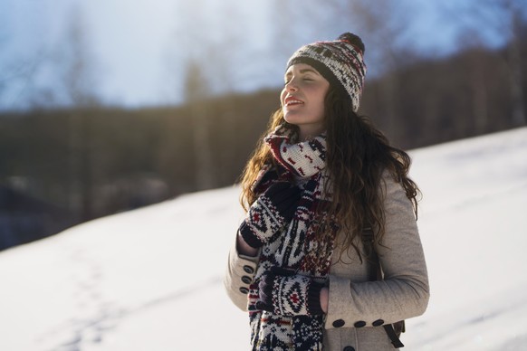 Beautiful young woman enjoying a carefree winter day in the nature.