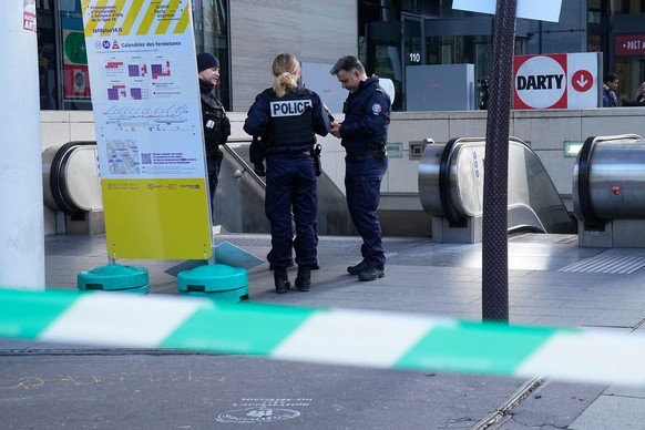 31.10.2023, Frankreich, Paris: Polizisten stehen in einem abgesperrten Bereich vor dem Eingang zu einer S-Bahn-Station. Die Polizei hat in einer Pariser S-Bahnstation eine Frau niedergeschossen, die d ...