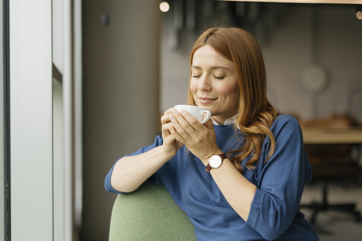 Woman enjoying a coffee break in a modern office model released, Symbolfoto property released, FLMZF00716