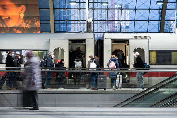 Bahnreisende steigen zur Weihnachtszeit auf dem Bahnsteig im Berliner Hauptbahnhof in einen ICE. Die Deutsche Bahn setzt zur Weihnachtszeit zusätzliche Züge ein.