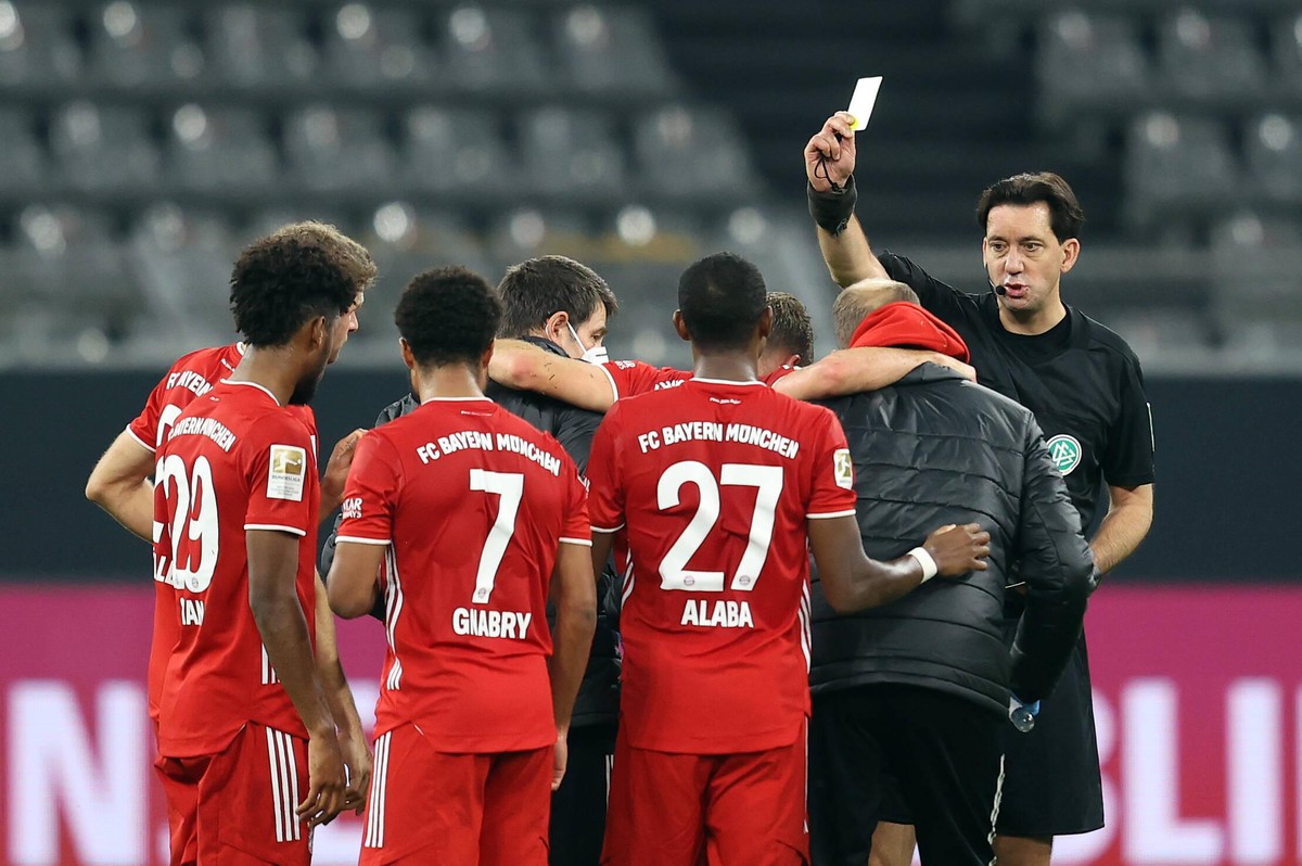 Auch das noch, aber so sind eben die Regeln: Schiedsrichter Manuel Gräfe (r.) zeigt Kimmich während des Abtransports die Gelbe Karte.