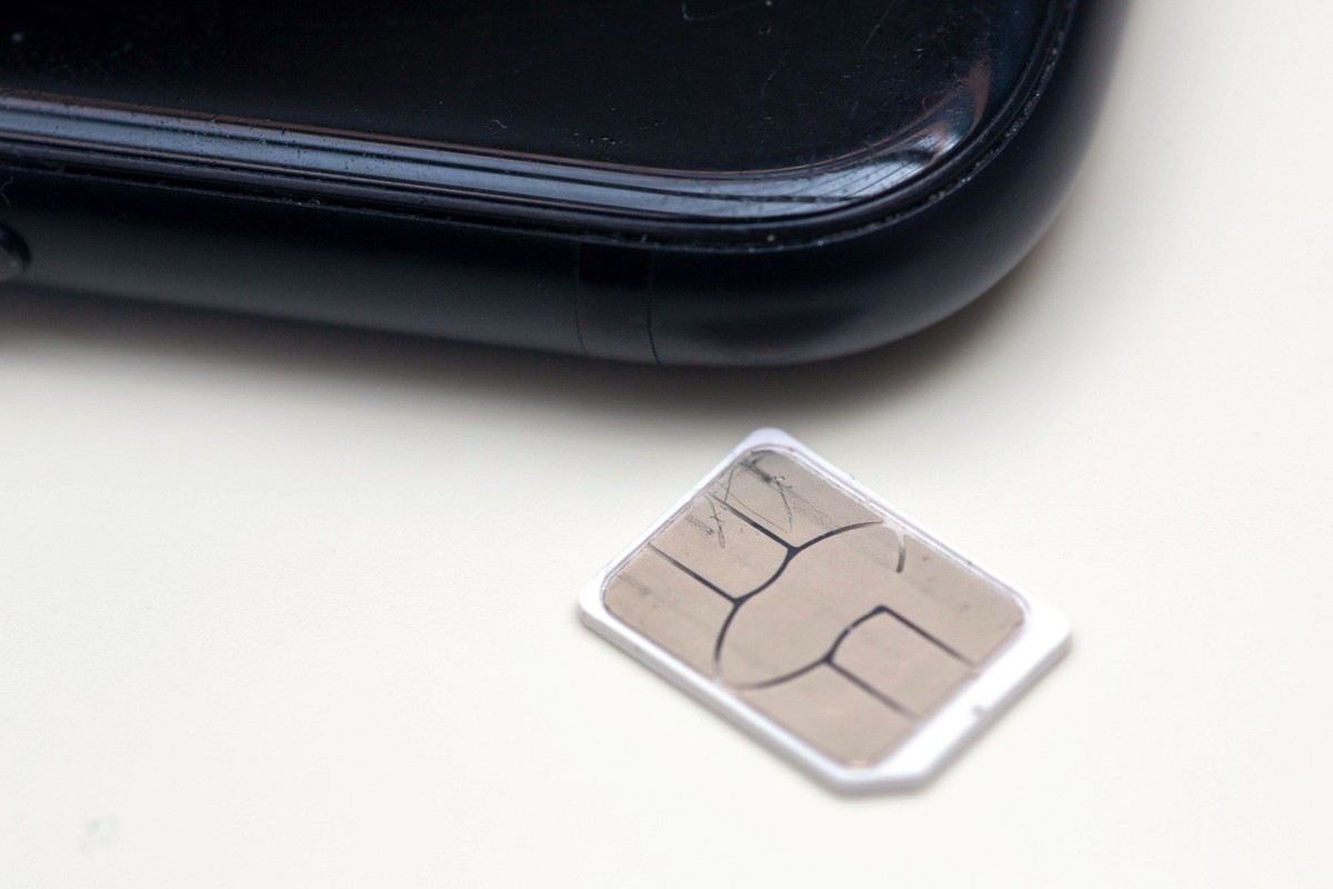 ARCHIV - 22.06.2023, Berlin: Eine SIM-Karte liegt auf einem Tisch neben einem Smartphone. Ein in Milliardenstückzahlen gefertigtes Requisit des Handy-Zeitalters verschwindet aus den ersten Mobiltelefo ...