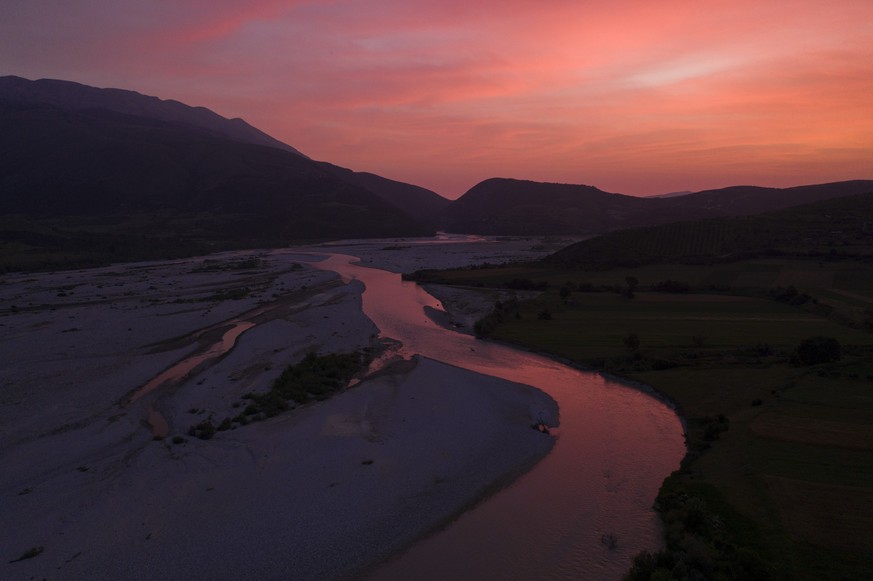 FILE - The sun sets behind the Vjosa River near Tepelene, Albania. Officials on Monday, June 13, 2022. The Albanian government on Wednesday, March 15, 2023 formally designated the Vjosa River and its  ...