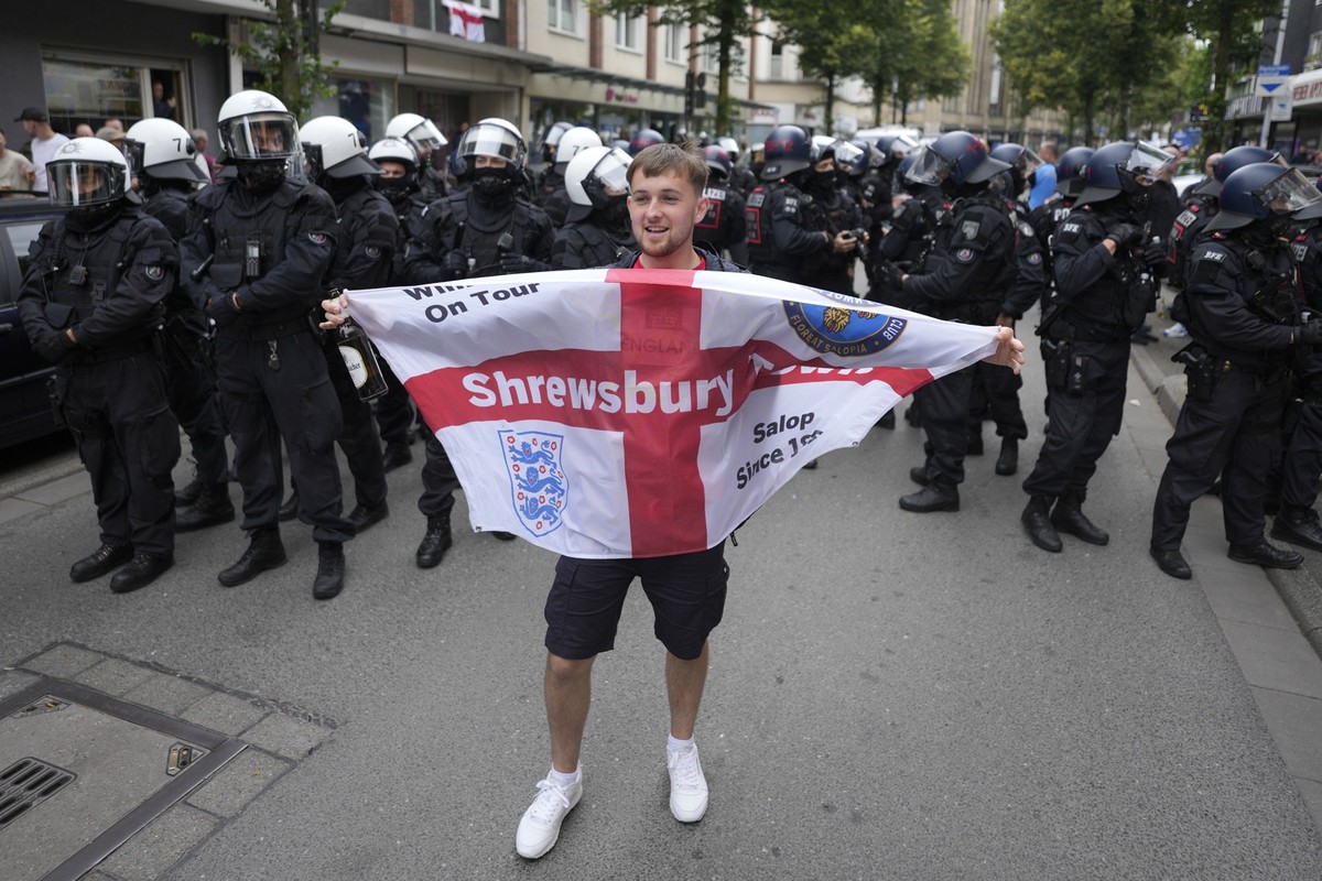 England soccer fan cheers in front of police line ahead the Group C match between Serbia and England at the Euro 2024 soccer tournament in Gelsenkirchen, Germany, Sunday, June 16, 2024. (AP Photo/Mark ...