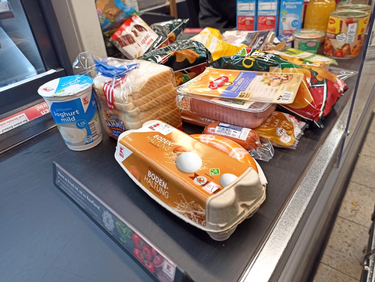 Einkauf in einem Supermarkt oder Discounter zu Zeiten von Inflation. Kasse, Kassenband, Kassenbereich, Einkaufswagen, Warenkorb, Einkauf in Zeiten von Corona und Krieg in der Ukraine und Inflation. ** ...
