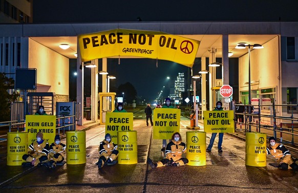 Aktivisten von Greenpeace blockieren am frühen Morgen den Haupteingang zur Erdölraffinerie der PCK-Raffinerie GmbH. Mit der Aktion protestiert Greenpeace gegen die fossilen Importe aus Russland und di ...