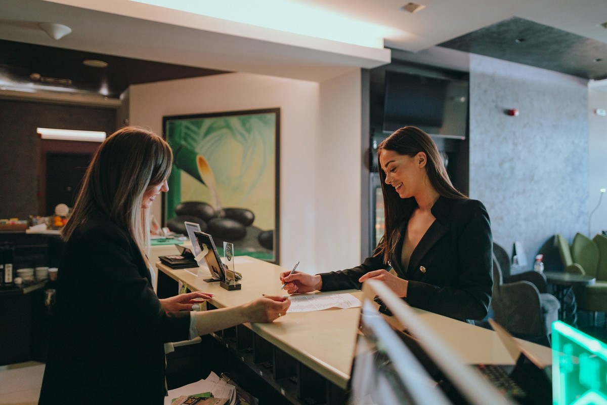 Young woman wearing a suit traveling for business check-in at the hotel reception
