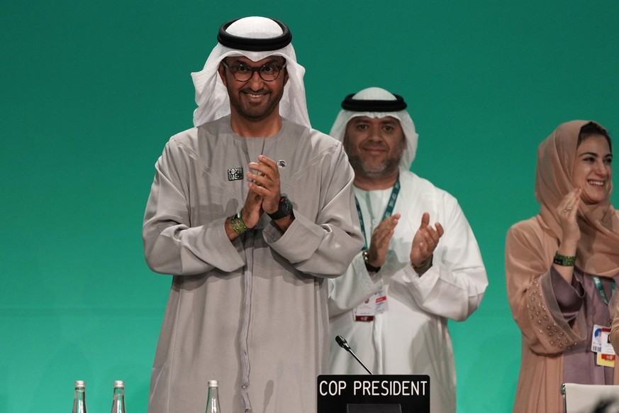 COP28 President Sultan al-Jaber, left, claps after passing the global stocktake at the COP28 U.N. Climate Summit, Wednesday, Dec. 13, 2023, in Dubai, United Arab Emirates. (AP Photo/Kamran Jebreili)