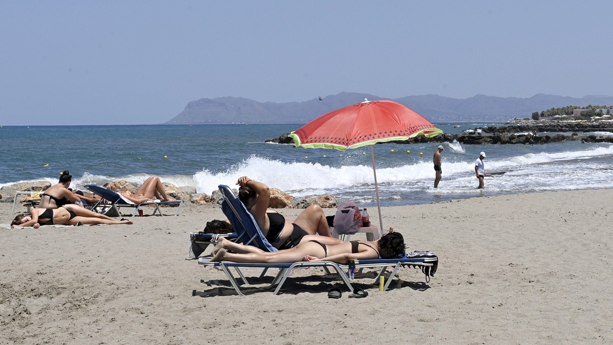 06.07.2022, Griechenland, Chania: Touristen sonnen sich an einem Strand auf der Insel Kreta. Foto: Heikki Saukkomaa/Lehtikuva/dpa +++ dpa-Bildfunk +++