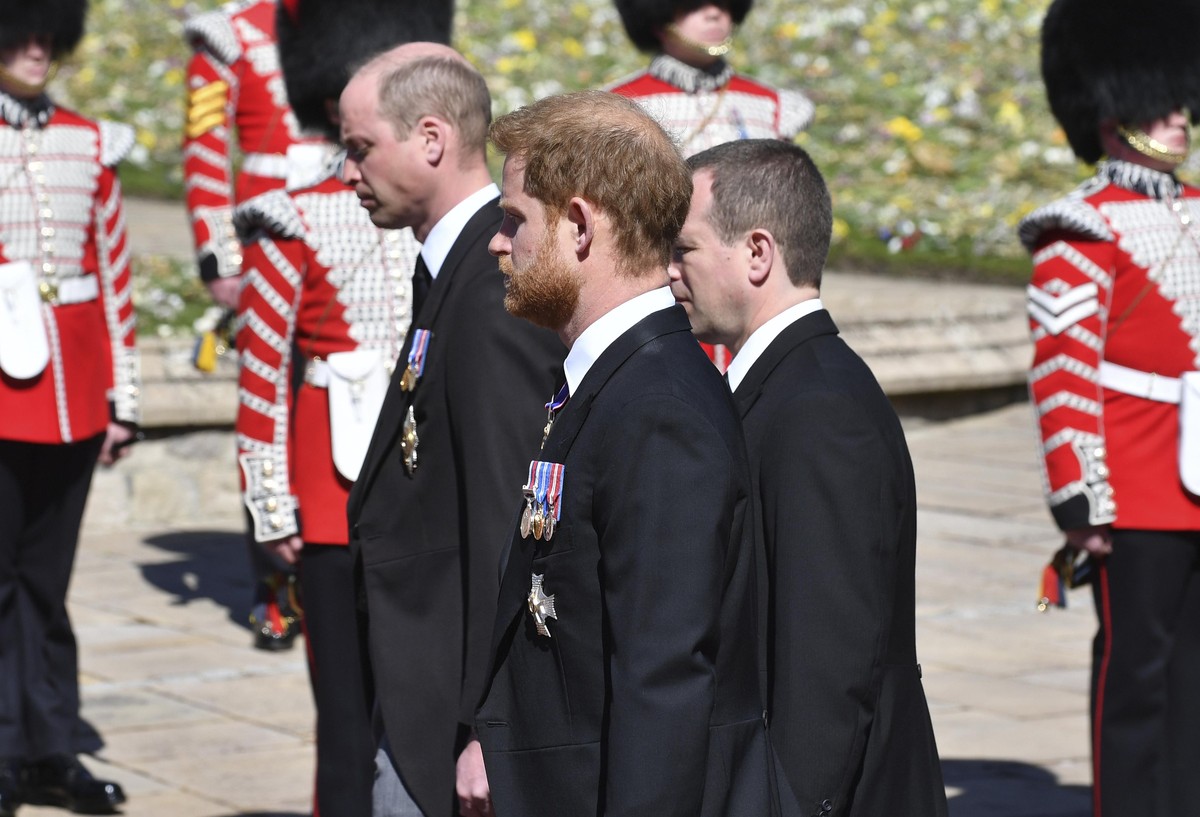 Prince William, left, Prince Harry and Peter Phillips, right, follow the coffin during a procession arriving at St George's Chapel for the funeral of Britain's Prince Philip inside Windsor C ...