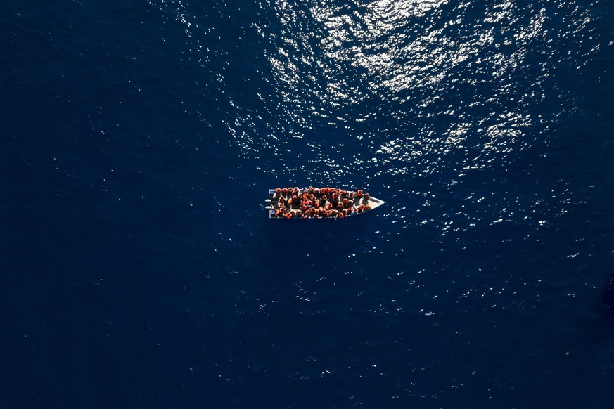 Migrants from Eritrea, Libya and Sudan sail a wooden boat before being assisted by aid workers of the Spanish NGO Open Arms, in the Mediterranean sea, about 30 miles north of Libya, Saturday, June 17, ...