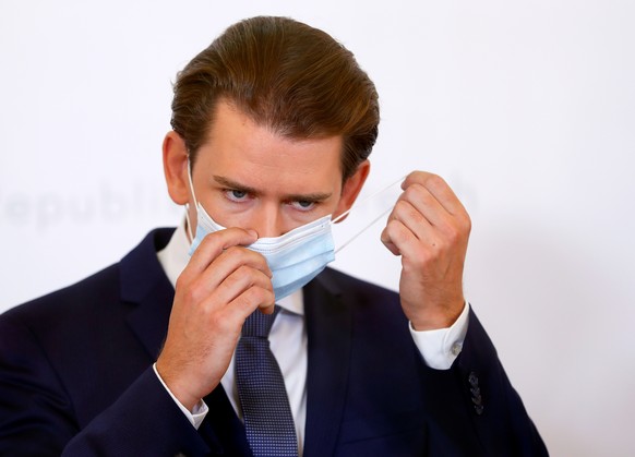 Austrian Chancellor Sebastian Kurz takes off a protective face mask as he arrives for a news conference as the coronavirus disease (COVID-19) outbreak continues, in Vienna, Austria September 11, 2020. ...