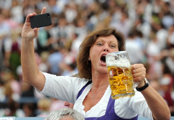 dpatopbilder Die bayerische Wirtschaftsministerin Ilse Aigner (CSU) fotografiert sich mit ihrem Handy, als sie am 20.09.2014 am Eröffnungstag des Oktoberfestes in München (Bayern) ihren Bierkrug in di ...