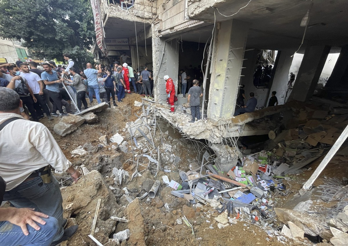 Residents and rescuers gather at the scene of a missile strike in the southern suburbs of Beirut, Friday, Sept. 20, 2024. (AP Photo/Bilal Hussein)