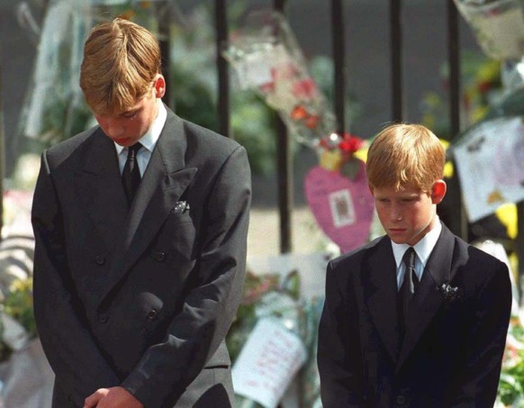 ARCHIV - 06.09.1997, Gro�britannien, London: Mit gesenktem K�pfen verfolgen Prinz William (l) und Prinz Harry wie der Sarg mit der Leiche ihrer Mutter nach der Trauerfeier aus der Londoner Westminster ...