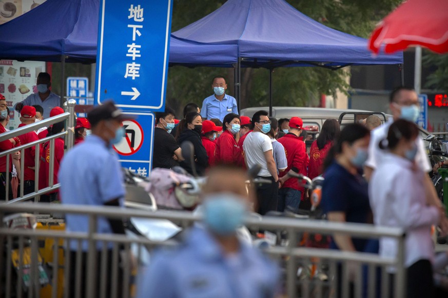 12.06.2020, China, Peking: Polizisten sichern einen Fleischmarkt, der von den Behörden geschlossen wurde, nachdem bekannt wurde, dass ein Besucher des Marktes am Donnerstag positiv auf das Coronavirus ...