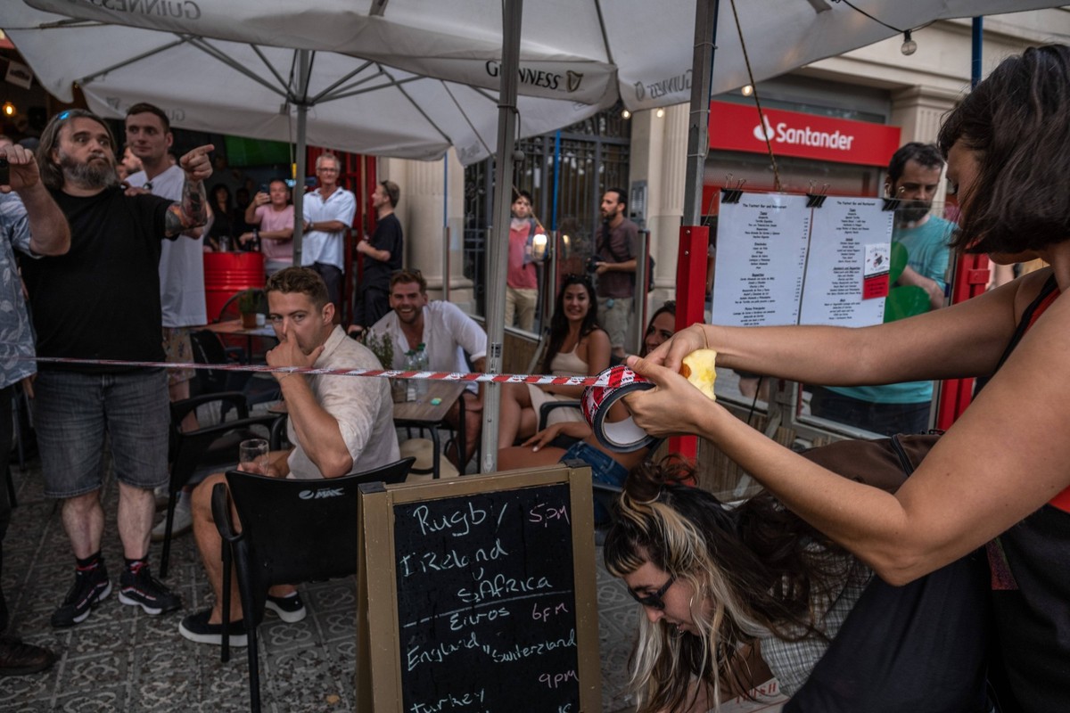 Demonstration for tourism decrease in Barcelona, Spain - 06 Jul 2024 A protester is seen symbolically closing the terrace of one of the restaurants in Barceloneta, which is very popular with tourists. ...