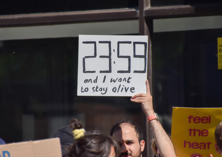 May 8, 2022, London, England, United Kingdom: A protester holds a sign referencing the Doomsday Clock. Activists gathered outside Shell headquarters in London in protest against the Jackdaw gas field, ...