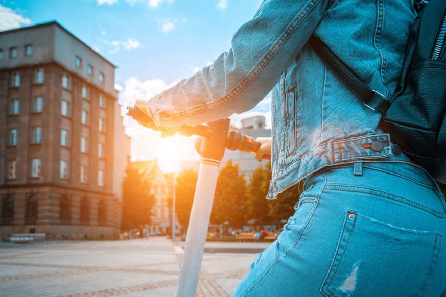 Scooter nature. Kick electric city bike using from business woman. Electric scooters for public share standing outside